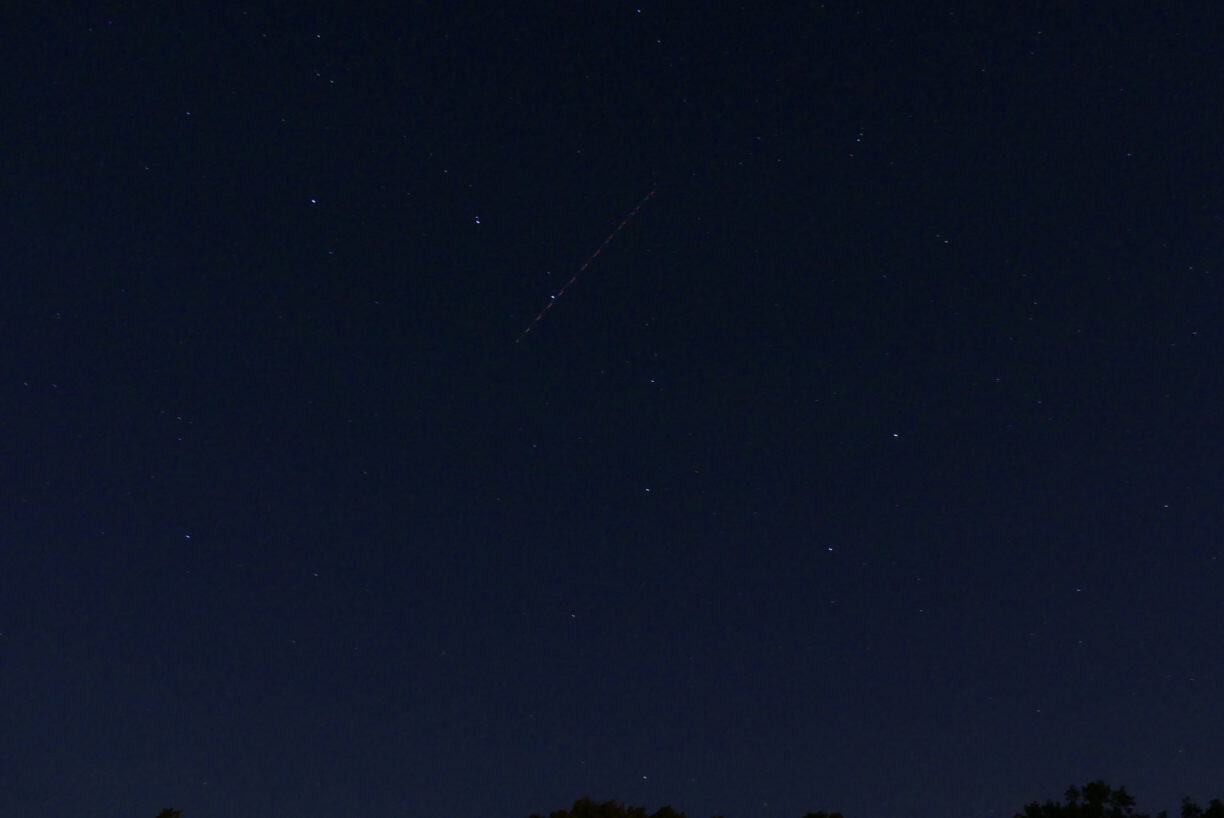 Das Sternbild Großer Wagen und ein Flugzeug im Himmel